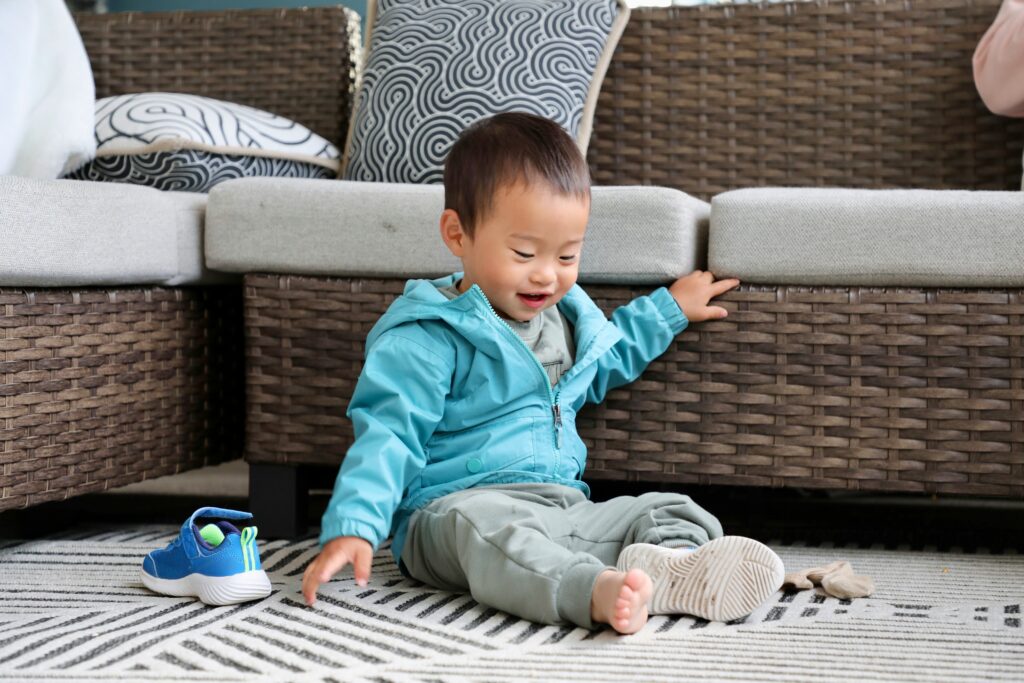 How to Get Kids to Do Their Morning Routine Independently A young child getting ready on their own in soft morning light, putting on shoes without a parent prompting them